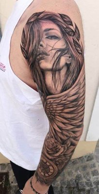 Tatouage plume avec une tête de femme sur l'intégralité du bras
